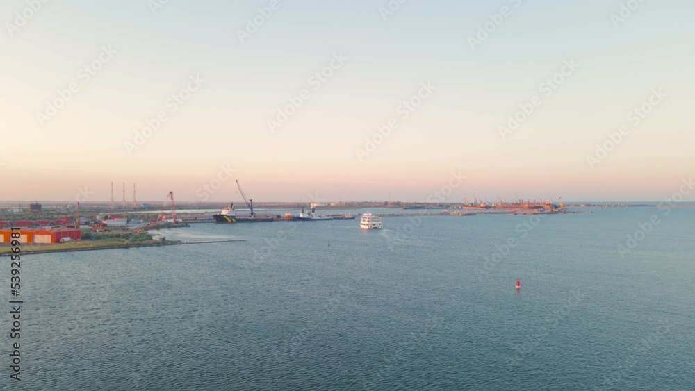 Aerial view of a harbor with ships sailing and docked. Footage was taken from a drone at a higher altitude in summer season at sunset in Navodari harbour, Romania. Aerial view of a harbor with ships sailing and docked. Footage was taken from a drone at a higher altitude in summer season at sunset in Navodari harbour, Romania.
