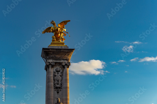 Paryż, Francja, most Aleksandra III nad rzeką Sekwaną, zbliżenie na złotą rzeźbę konia na zdobionym filarze.