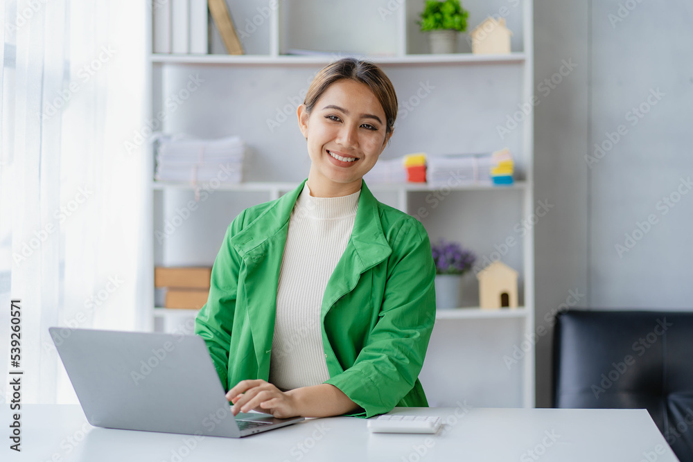 Independent Asian woman working from home Business woman using laptop sitting on a desk in home office, lifestyle concept, woman working online on the internet. Independent Asian woman working from home Business woman using laptop sitting on a desk in home office, lifestyle concept, woman working online on the internet.