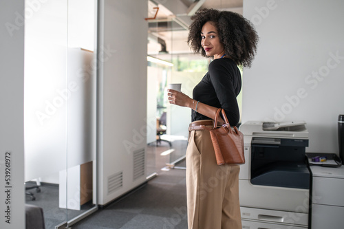 Confident curly-haired business woman in the office photo