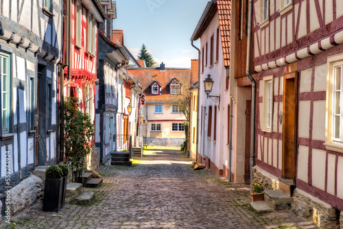Gepflasterte Straße mit sanierten Fachwerkhäusern am Rand im historischen Stadtkern von Idstein im Taunus, Hessen, Deutschland © Frank Wagner