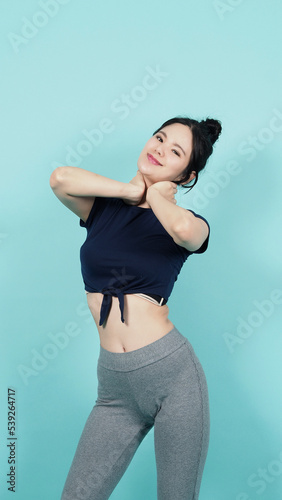 Fitness sportswear woman smile and pose body exercise at camera isolated on blue green background. Perfect body sporty woman relaxing after training. Fit and firm people. Sport Health and wellness.