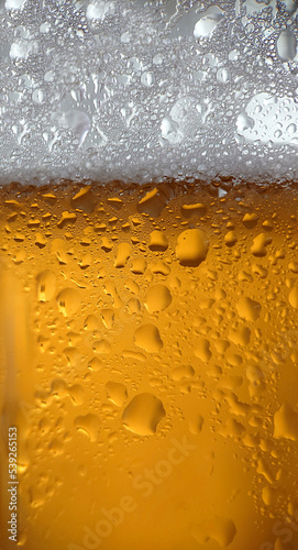 White foam and condensation on a glass of cold beer