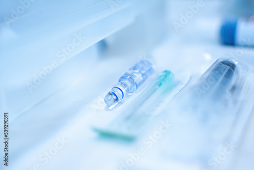 Close up of glass medical ampoule lying on desk in dental office. Ampoule in dental office.