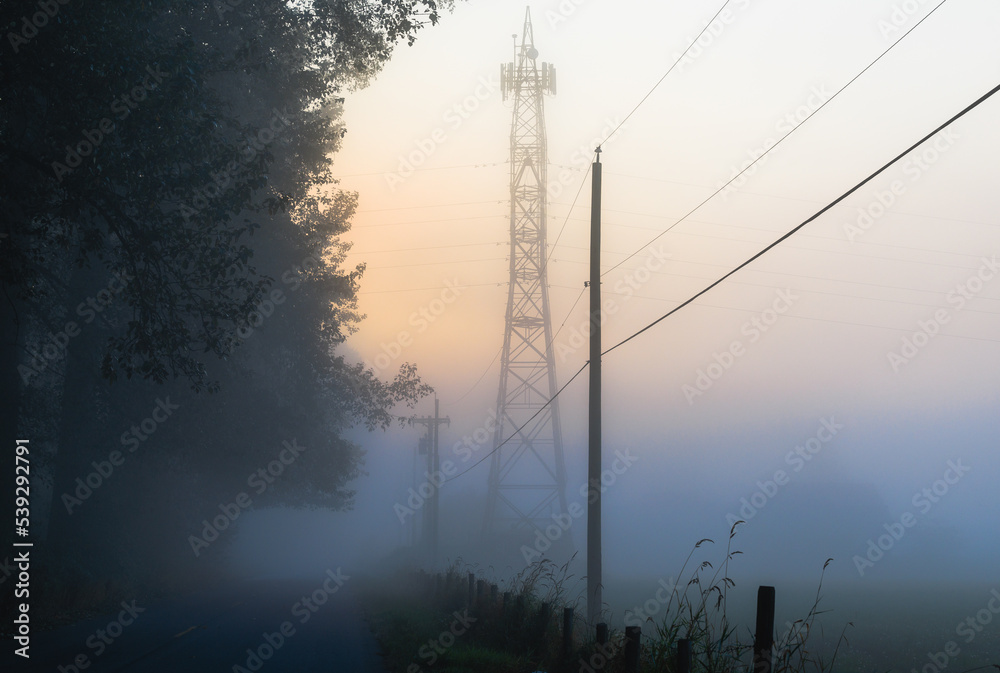 Power tower in early morning fog