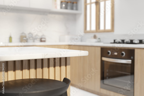 Blurred interior of modern kitchen with white walls, white tile floor, white countertops and wooden cupboards and accents. Table for your product in foreground or as a background image. 3d rendering