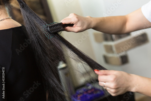 Stylist working with client in salon, closeup.
