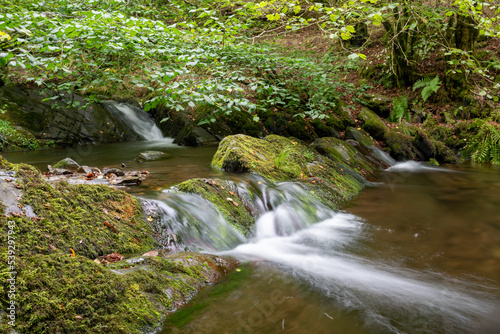 Long exposure of a waterfall on the Horner Water river in Horner woods in Somerset