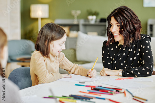 Photography Portrait of young jewish woman drawing pictures with little daughter at home