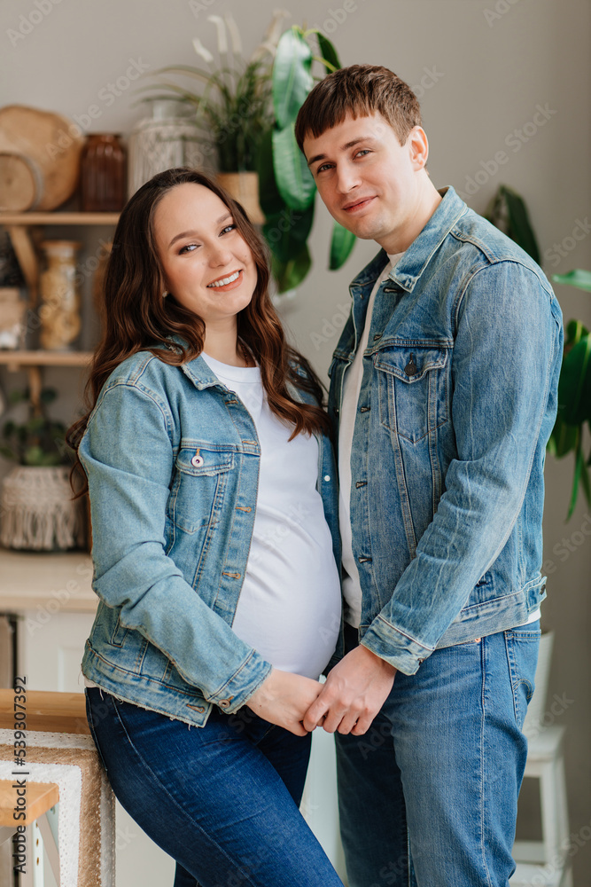 a pregnant woman and a man in denim. fashionable and comfortable clothes