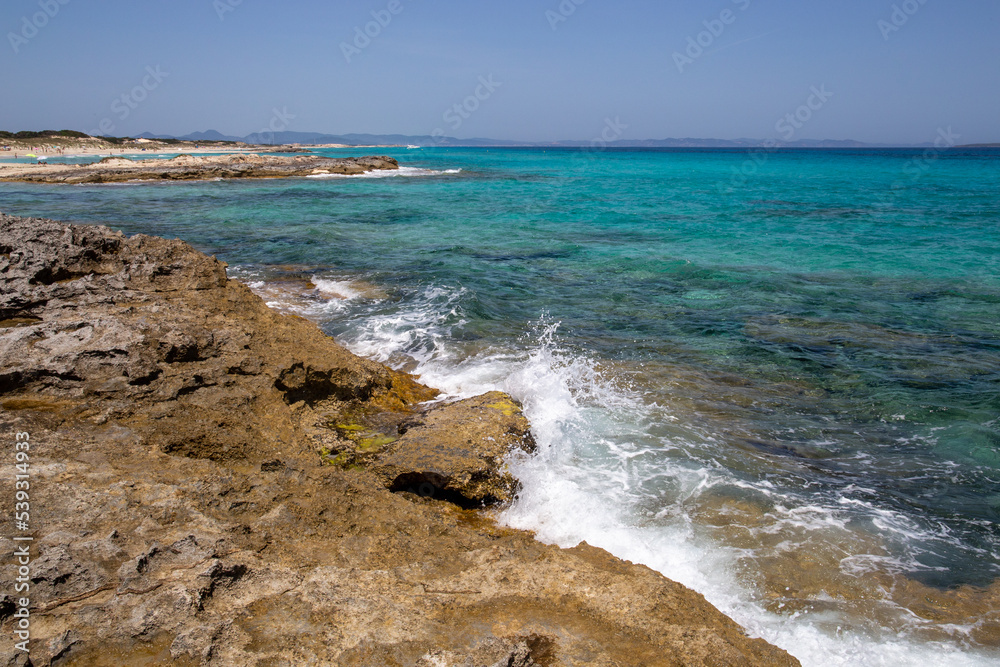 Rocky beach with a turquoise blue sea and waves in spain Rocky beach with a turquoise blue sea and waves in spain