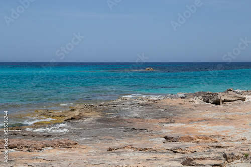 Rocky beach with a turquoise blue sea and waves in spain