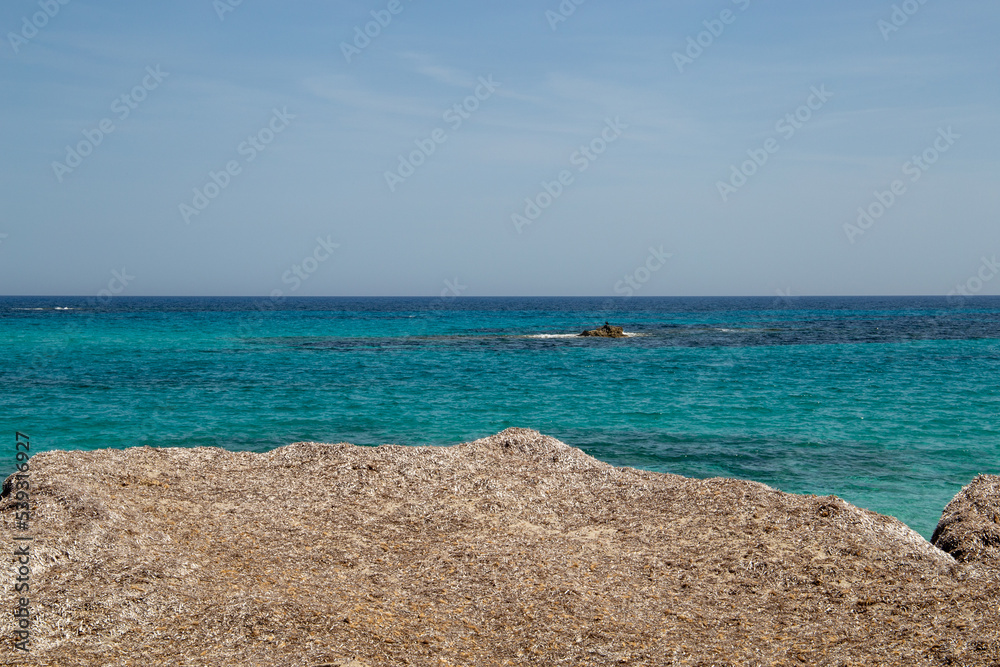 Rocky beach with a turquoise blue sea and waves in spain