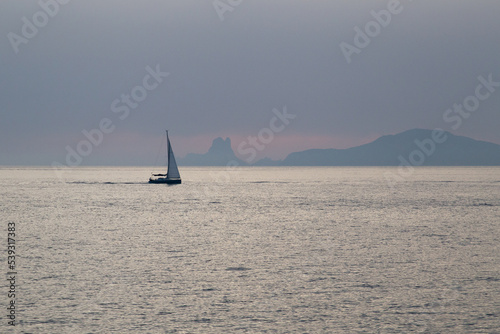 Sailboat sailing in the Mediterranean during sunset with an island behind © Rafael Prendes
