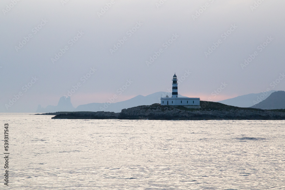 Lighthouse on a Mediterranean island during sunset.