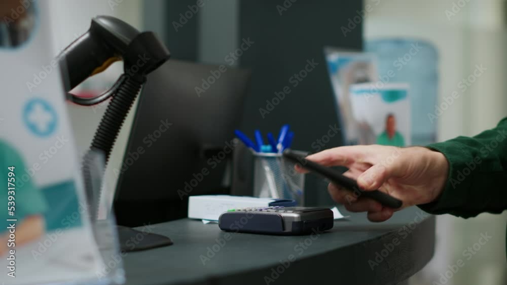 Elderly person paying medicaments and drugs with telephone and nfc, making payment at pharmacy counter to buy prescription treatment. Using mobile phone to pay vitamins. Close up. Tripod shot. Elderly person paying medicaments and drugs with telephone and nfc, making payment at pharmacy counter to buy prescription treatment. Using mobile phone to pay vitamins. Close up. Tripod shot.
