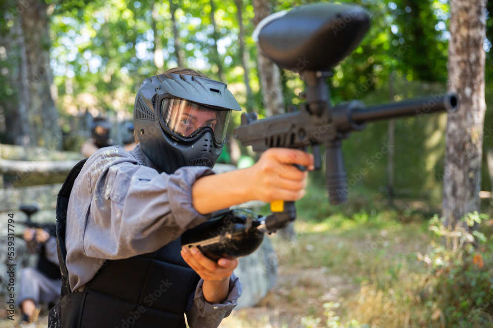 Fototapeta premium Paintball player recklessly aims with a gun on the battlefield