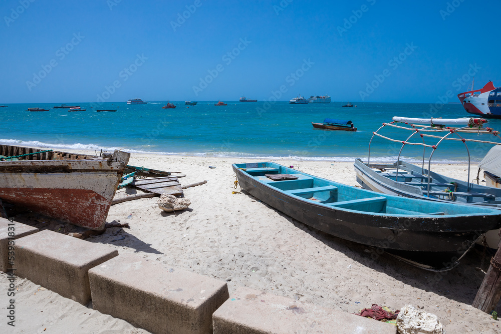 Vintage boats lying on the snow-white beach of the island of Zanzibar. 