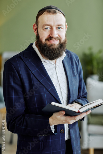 Valokuva Vertical portrait of bearded jewish man wearing kippah and looking at camera hol