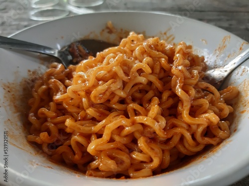 Noodles in a bowl ready to eat isolated on a wooden table