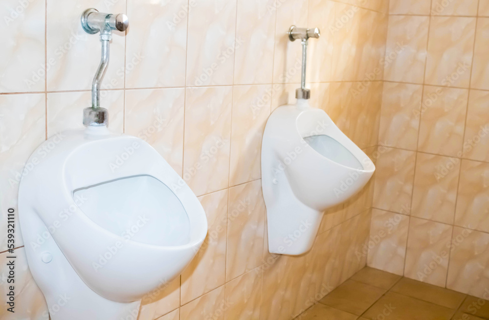 Fototapeta premium Close up used modern white urinal in the toilet.Sanitary of men toilet concept.