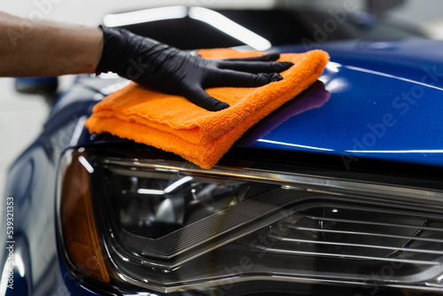 Hand car drying with microfiber in detailing auto service. Cleaner worker dry body car after washing automobile. © Rabizo Anatolii