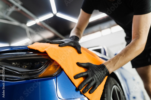 Fotografie, Obraz Hand car drying with microfiber in detailing auto service