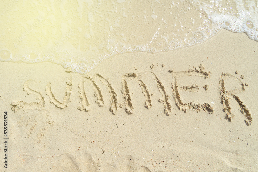 Fototapeta premium Word Summer on beach - vacation concept background. Sea, wave, sand, inscription summer on the sand.
