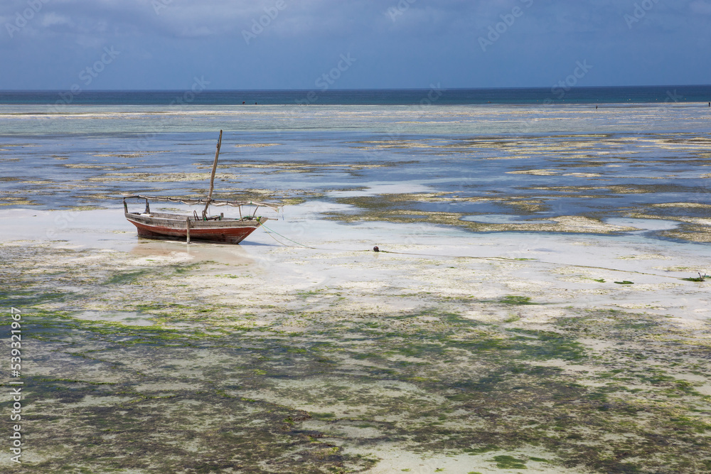 Lonely old fishing boat on the shallows. The water has gone too far. Ocean view Lonely old fishing boat on the shallows. The water has gone too far. Ocean view