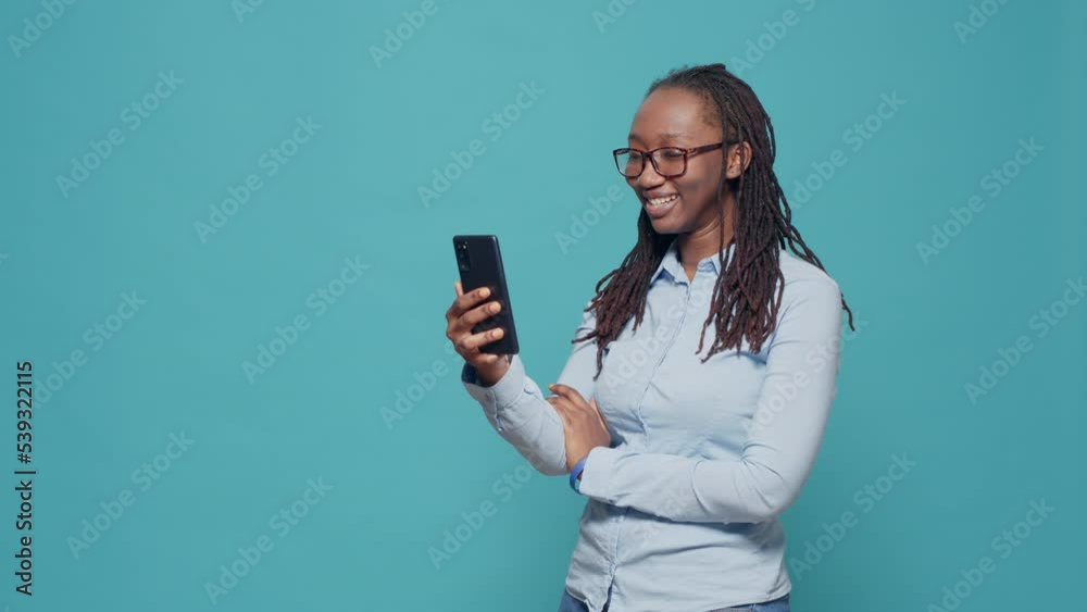Female model attending online videocall meeting on smartphone, talking on videoconference call with people. Using mobile phone app and webcam to chat on remote teleconference.