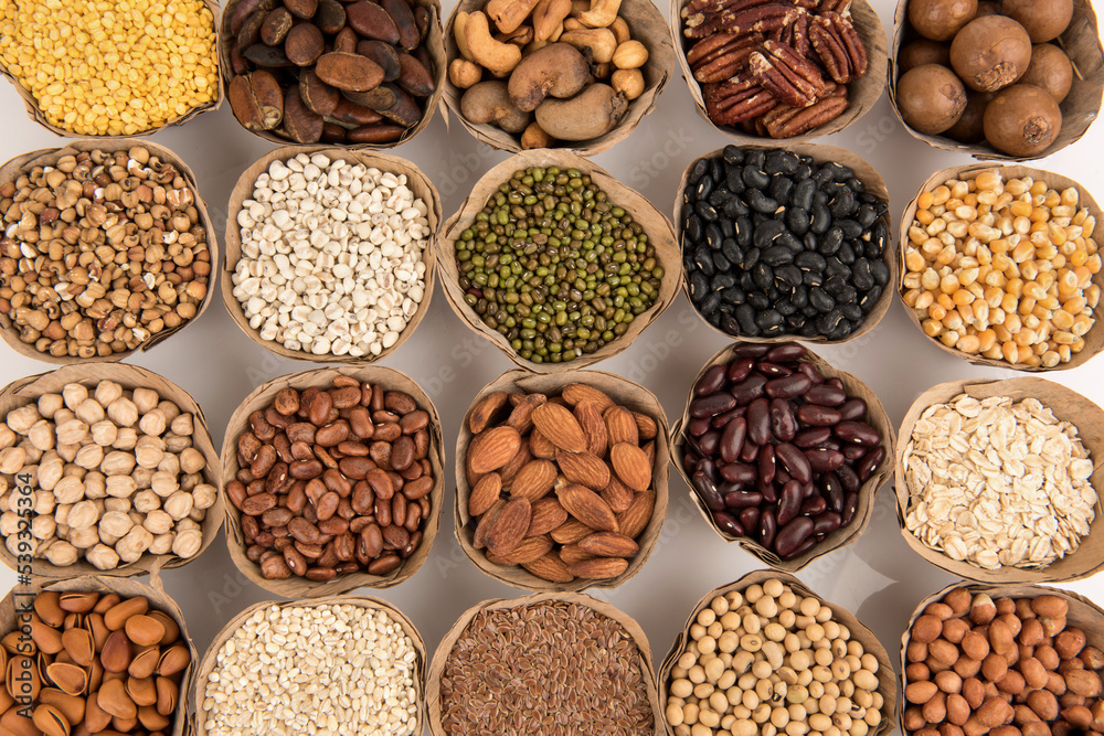 Many cereals such as walnuts, macadamia, green peas, almonds and others isolated on white background.
