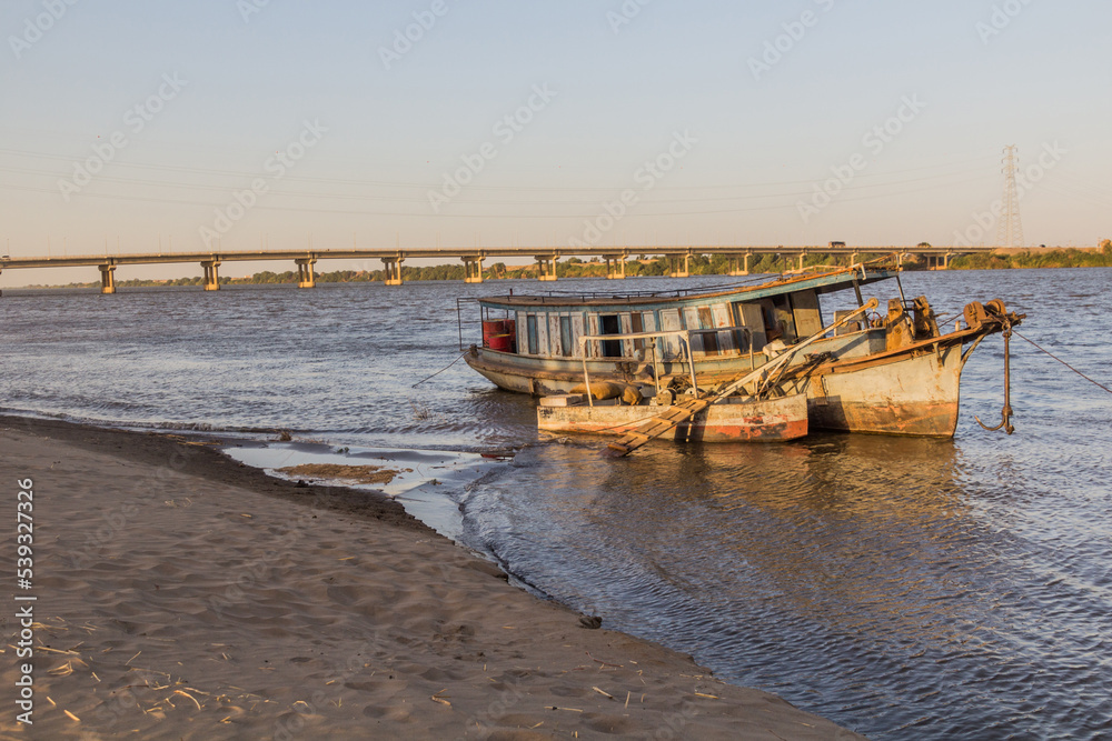 Old boat and a bridge over river Nile in Dongola, Sudan