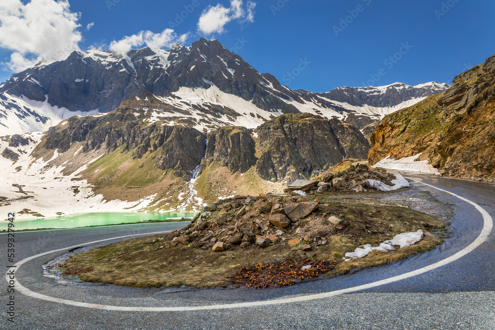 Alpine mountain road between snow at springtime, Gran Paradiso Alps, Italy