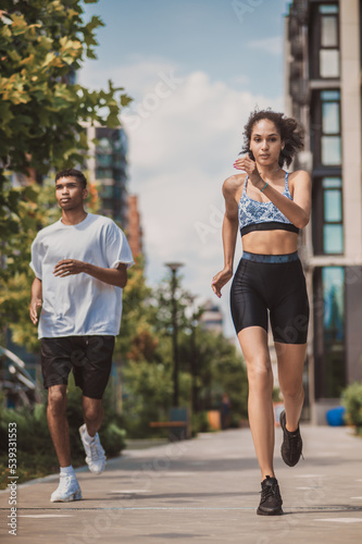 Two young people in sportswear running together