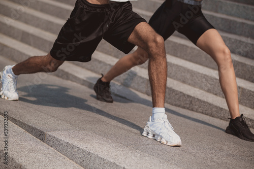 Close up of two people doing leg lunges together