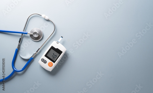 World Diabetes day concept ,14 November. Top view of blood glucose meter sets and stethoscope on pastel blue background.