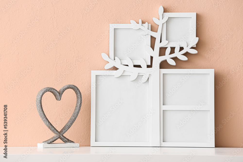 Family tree with photo frames and decor on table near beige wall Family tree with photo frames and decor on table near beige wall