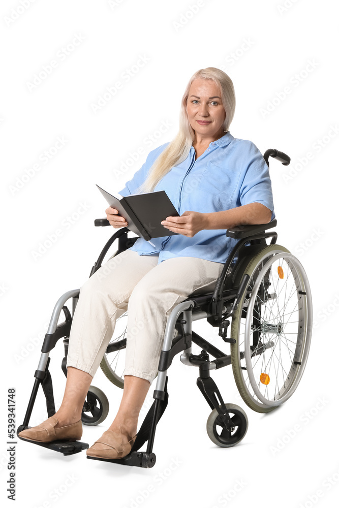 Mature woman in wheelchair reading book isolated on white Mature woman in wheelchair reading book isolated on white