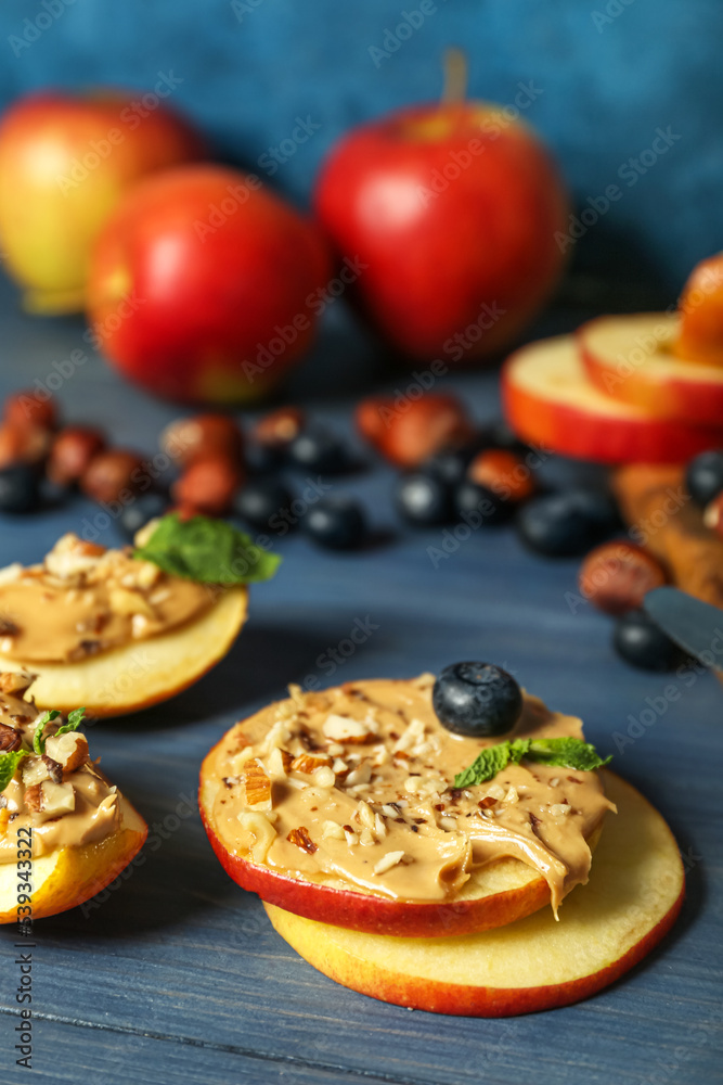 Fresh apple rounds with nut butter on color wooden table, closeup Fresh apple rounds with nut butter on color wooden table, closeup