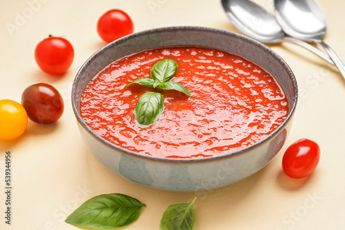 Fotografie Bowl of delicious tomato soup on color background, closeup