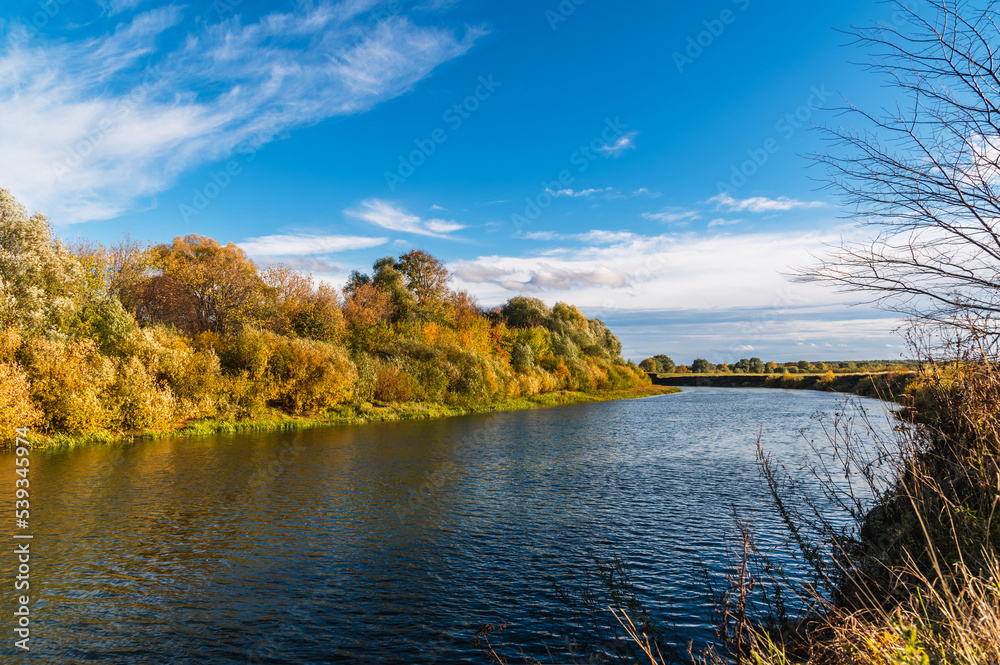 Calm flat river on a sunny autumn day.