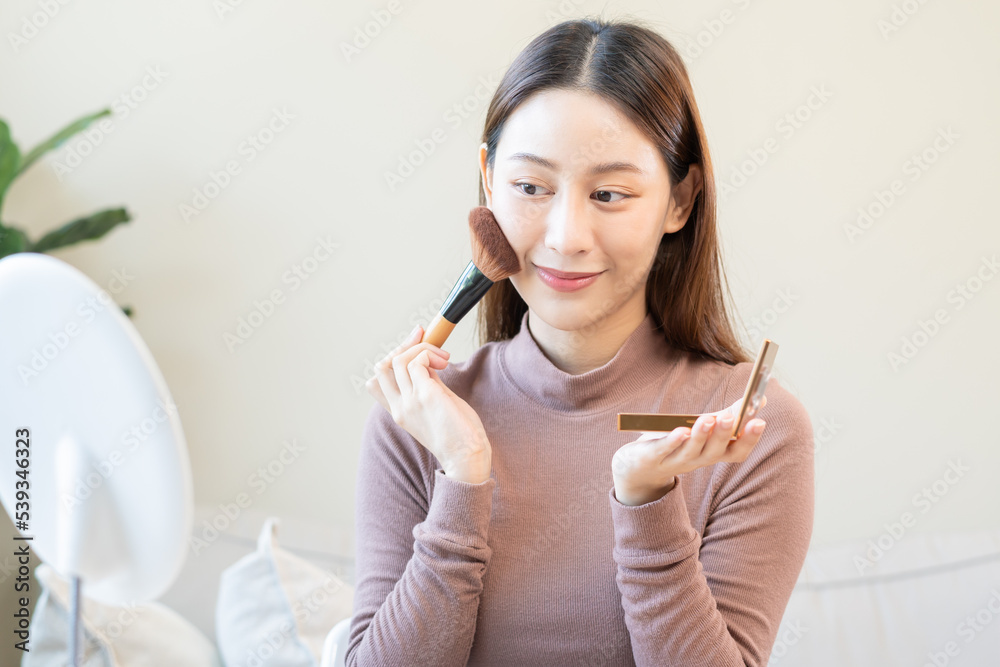 Happy routine beauty concept, pretty asian young woman, girl make up face by applying powder foundation by brush around face, looking at the mirror at home. Female look with natural fashion style. Happy routine beauty concept, pretty asian young woman, girl make up face by applying powder foundation by brush around face, looking at the mirror at home. Female look with natural fashion style.