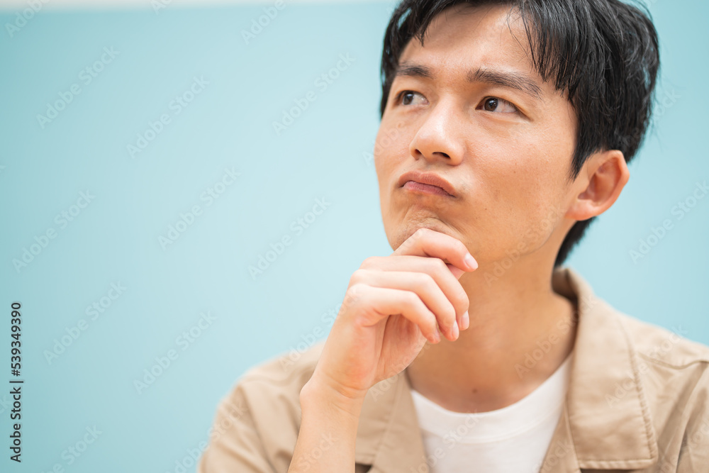ジャケットを着た考える若い日本人男性 ジャケットを着た考える若い日本人男性