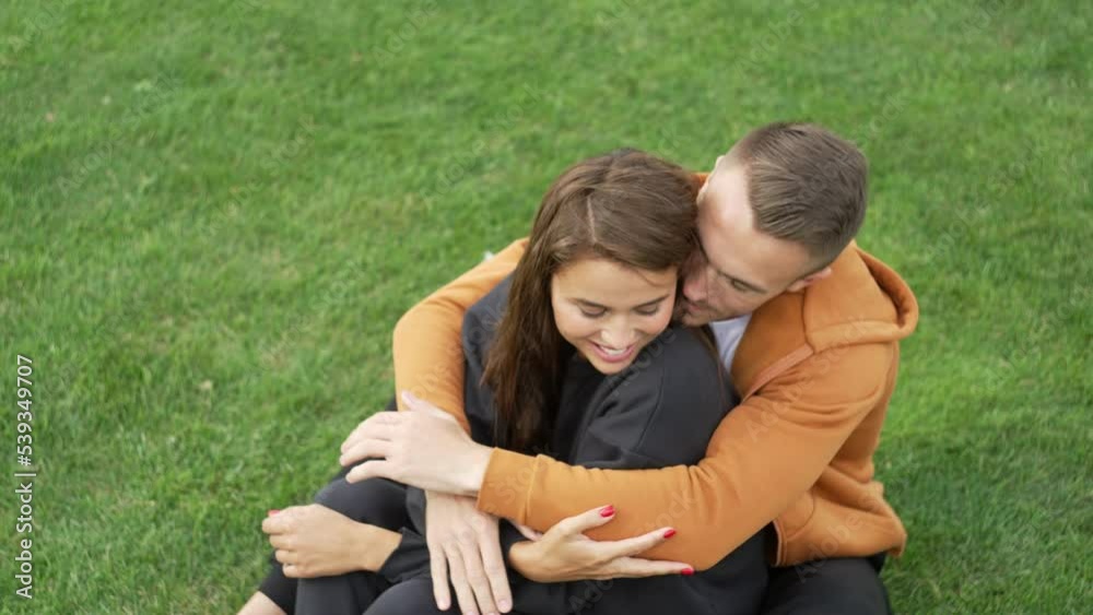 Close-up of a man hugging a woman in a summer park. Happy couple together on a date. The concept of family warmth, the happiness of the smiles of loved ones. High quality 4k footage Close-up of a man hugging a woman in a summer park. Happy couple together on a date. The concept of family warmth, the happiness of the smiles of loved ones. High quality 4k footage