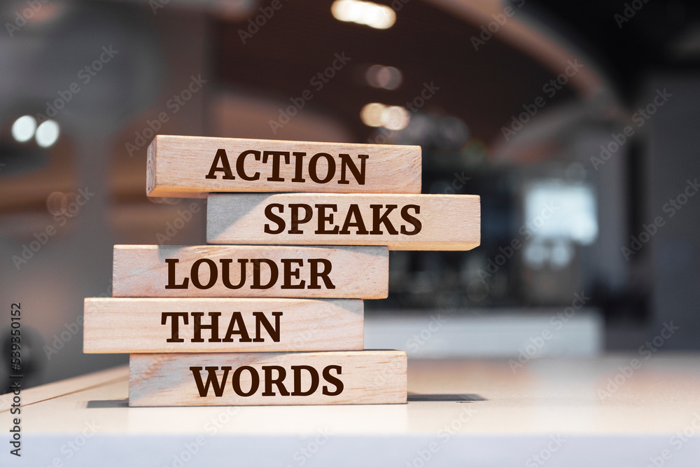 Wooden blocks with words 'Action Speaks Louder Than Words'.