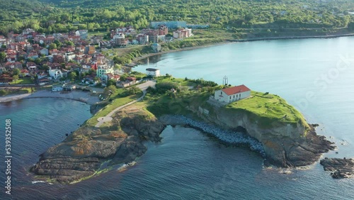 Aerial view of beautiful cape in Tsarevo with small church standing on top of the rocky hill photo