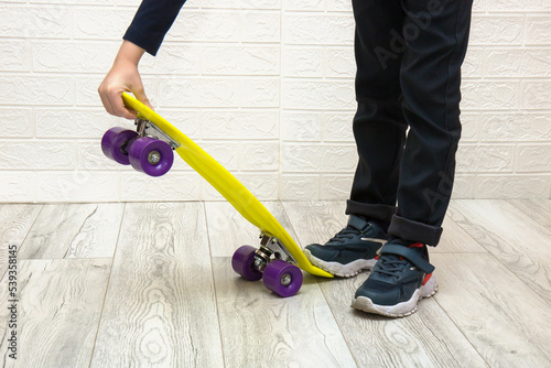 children's hand lifts the skate by stepping on it with their foot