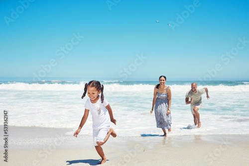 Summer, travel and family running at beach for vacation, freedom and happy together. Holiday, fun and wellness with parents playing with girl in ocean water for health, energy and youth lifestyle