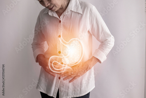 asian elderly woman having stomach ache on isolated background.