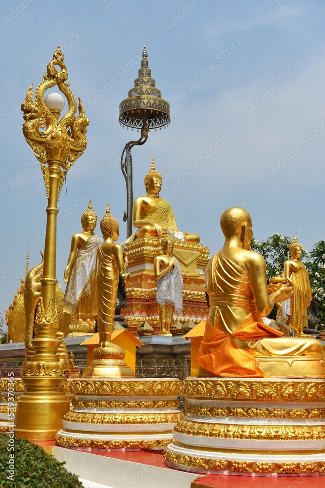 Fototapeta premium Various Buddha statues are located beside the chapel of Wat Phra That Phanom. This temple is a popular pilgrimage destination for those born in the year of the Monkey.